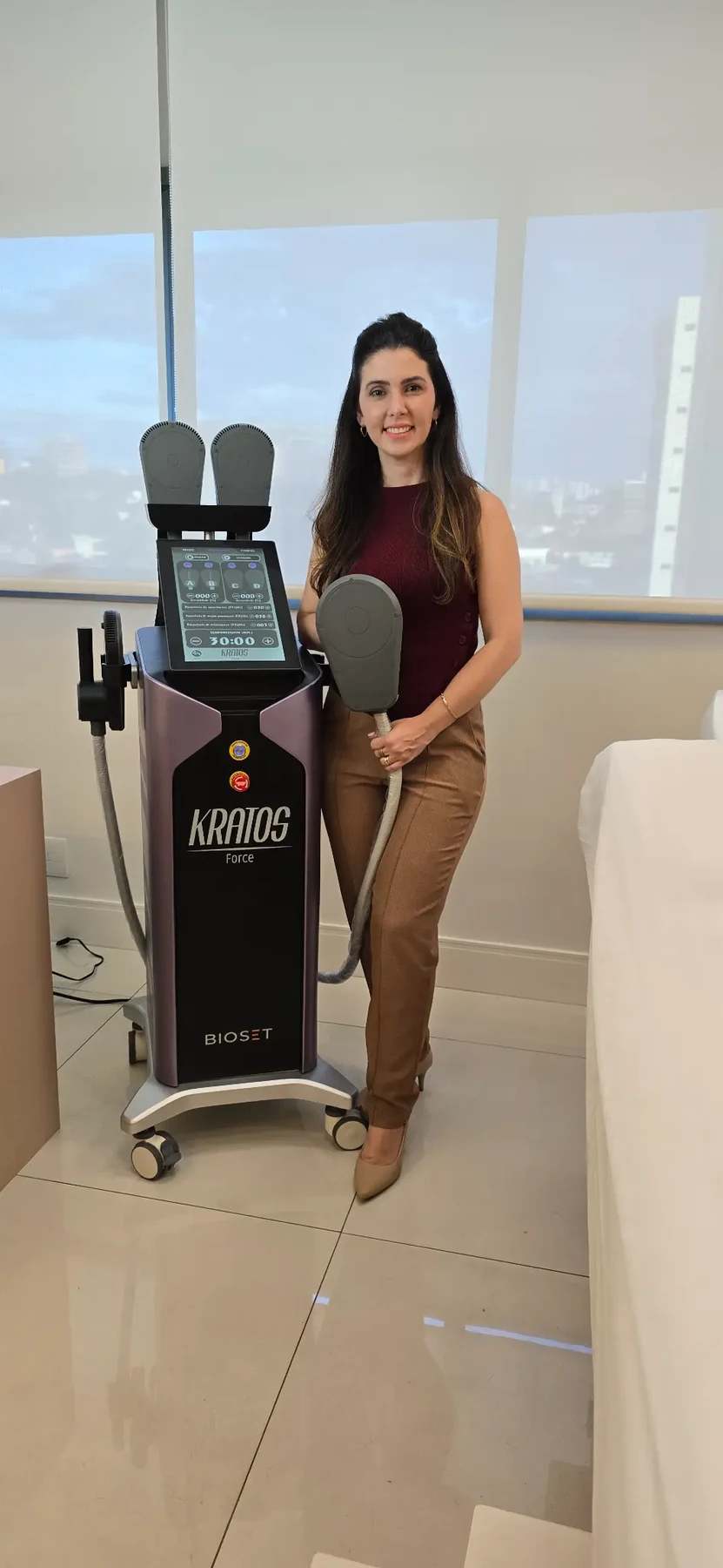 Dra. Luciane Naldoni ao lado de um equipamento na clínica no Cambuí, Campinas